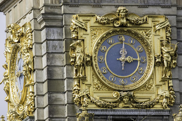 An ornate gold clock at 3pm