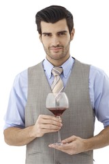 Portrait of young man with glass of wine