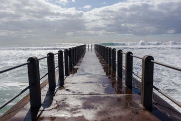 Fototapeta premium Beach Pier Waves ocean storm swells crashing water power