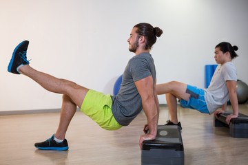 Two men doing aerobic exercise on stepper