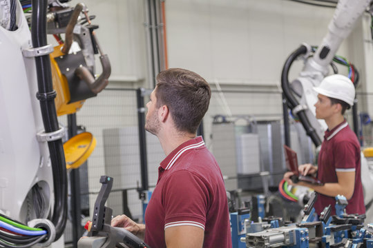Maschinenbauingenieure pr&uuml;fen einen Schweissroboter