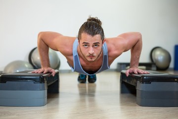 Portrait of man doing aerobic exercise on stepper