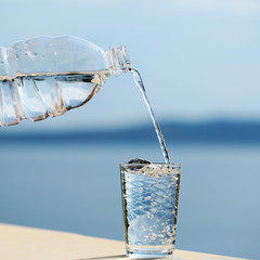 water pouring into glass from bottle © Volodymyr