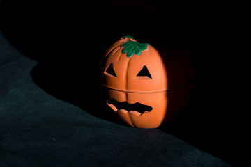 single spooky halloween pumpkin lighted sidewards on dark background
