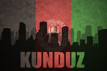 abstract silhouette of the city with text Kunduz at the vintage afghanistan flag background