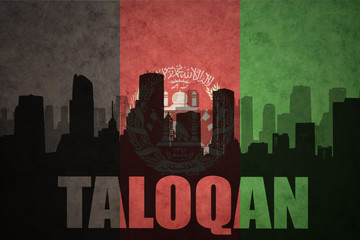 abstract silhouette of the city with text Taloqan at the vintage afghanistan flag background