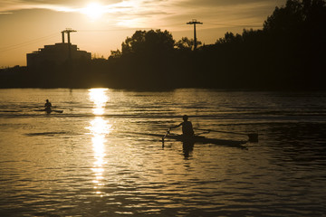 People rowing on Guadalquivir river at sunset, Seville, Spain
