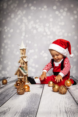 Baby spielt mit Christbaumkugeln