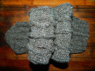Grey knitted sock with a large pattern on a wooden board