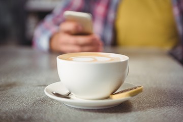 Coffee cup and cookie on a table