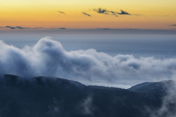 Dawn with Fog Over Ocean and Mountains