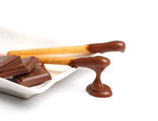 Biscuit cookie sticks in cacao coating with milk chocolate chunk
