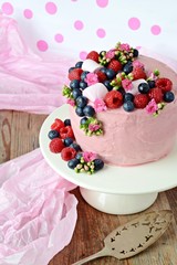 Pink cake with berries on the cake stand