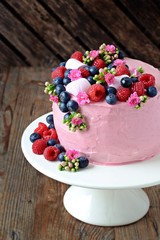 Pink cake with berries on the cake stand