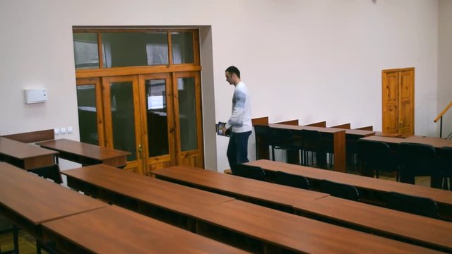 The student leaves the lecture hall. He closes the door behind him.