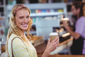 Portrait of smiling woman holding cup of coffee