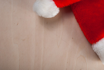 Obraz na płótnie Canvas Santa Claus hat on a wooden table with empty copy space