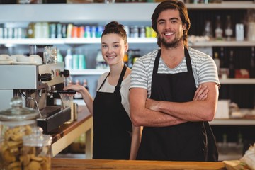 Portrait of waiter and waitress making cup of coffee at counter - obrazy, fototapety, plakaty