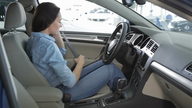 Woman sits inside the car at the dealership