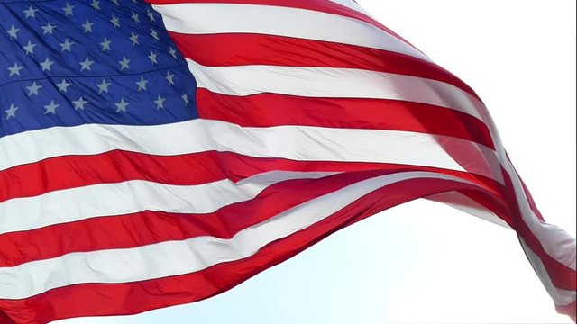 Moving and amazing slow motion closeup of American Flag gracefully waving in breeze.
