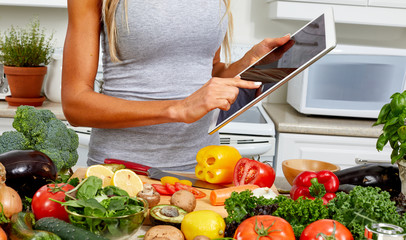 Young woman with tablet in the kitchen.