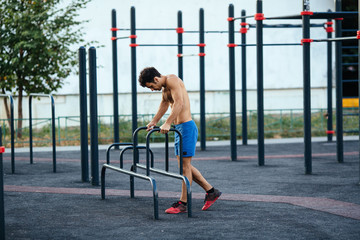 Fototapeta na wymiar Muscular man warming up before exercise at crossfit ground doing push ups as part of training. Sport concept