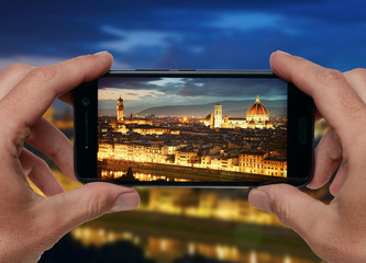 Travel concept. Hands taking photo of night city with smartphone