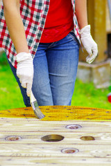 woman wearing gloves applying lacquer to a table