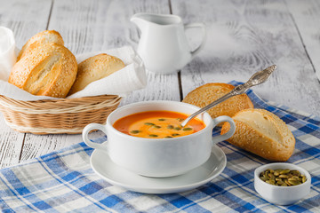 Fresh carrot soup in white bowl, dietary vegetable soup, rustic