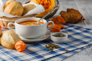 A bowl of spicy pumpkin soup, swirled with milk cream