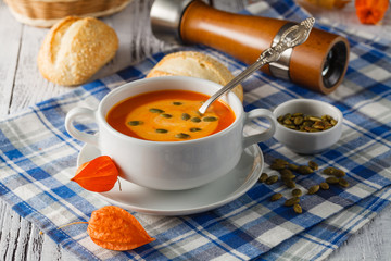 Traditional pumpkin soup with seeds and fresh just baked rye ban