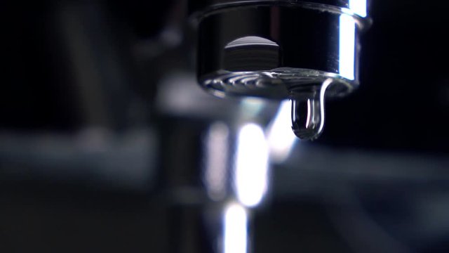 Dripping faucet. Leakage concept. Super slow motion extreme close up shot