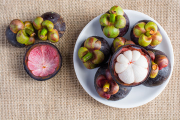 Mangosteen and cross section showing the thick purple skin and w