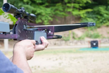 Wandaufkleber Man targeting with a scoped crossbow © andras_csontos