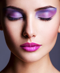 The girl's face closeup with purple eye make-up. fashion makeup