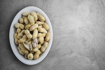 Boiled peanuts in white cup on old cement concrete texture backg