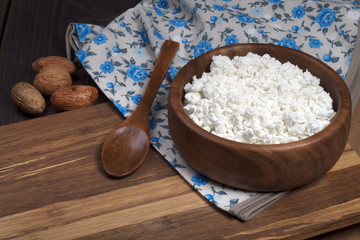cottage cheese in wooden cup with wooden spoon