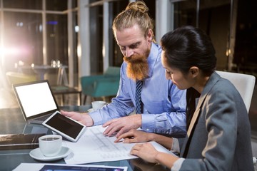Fototapeta premium Businesswoman and colleague discussing over blueprint