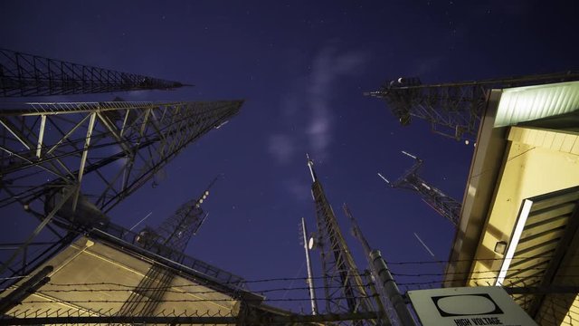 Time Lapse with tilt down motion of broadcast radio tower at night shot through storm clouds at Mt. Wilson, California