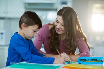 Fototapeta premium Mother helping her son with homework