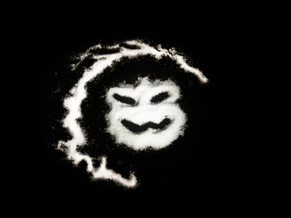 Horror evil face on black background, made from salt and sugar