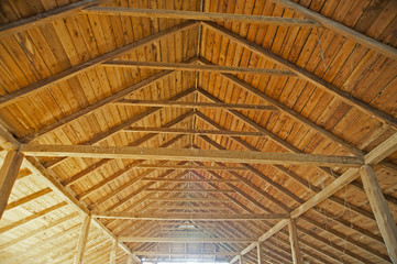 Wooden roof inside a large shed.