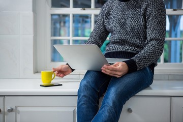 Man using laptop in the kitchen