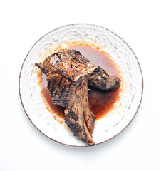 Grilled lamb steak on a plate on a white background