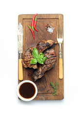 Grilled lamb steak on a cutting board on a white background