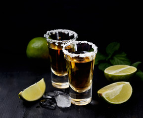 Tequila with salt and lime on a dark background