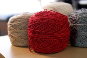 Balls of wool cotton silk yarn on wood table Red Gray White and Brown