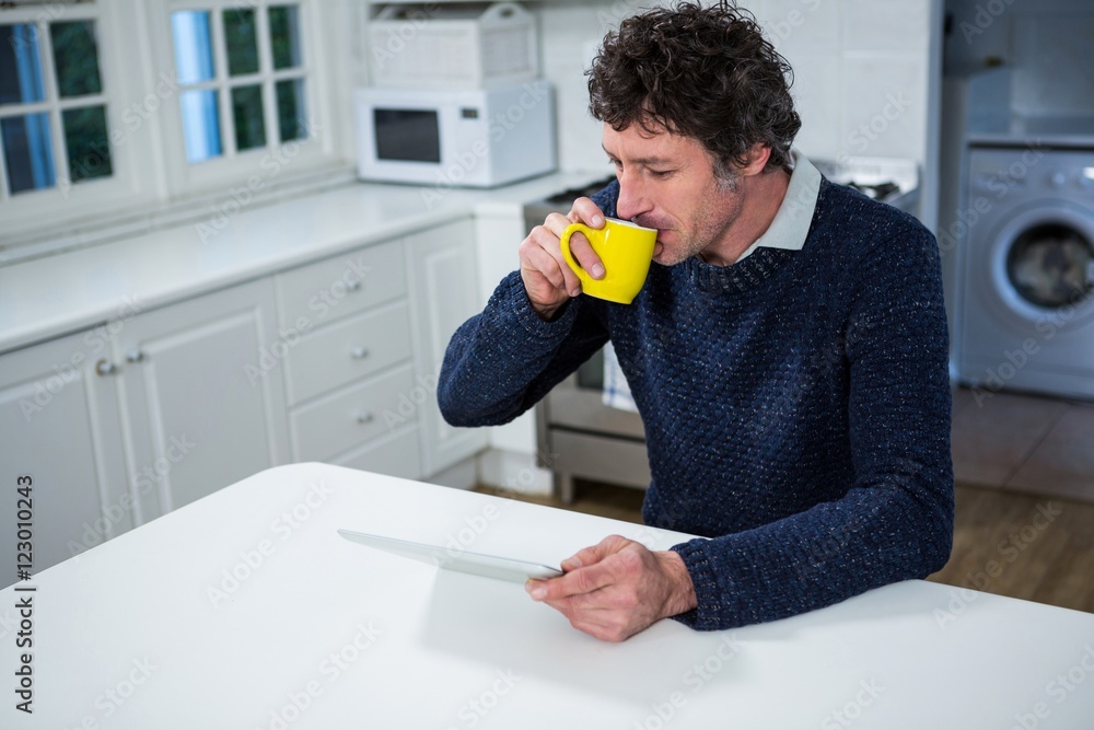 Poster Man using digital tablet while having coffee