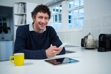 Man holding mobile phone in the kitchen