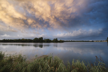 Stunning dramatic mammatus clouds formation over lake landscape